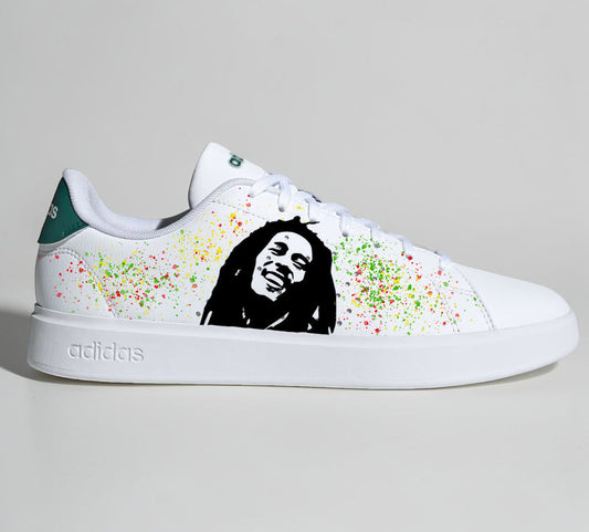 Baskets Adidas blanches personnalisées avec portrait de Bob Marley et éclaboussures de peinture rasta.